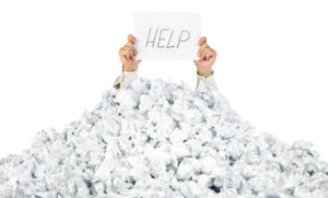 A under a crumbled pile of paper looking for help