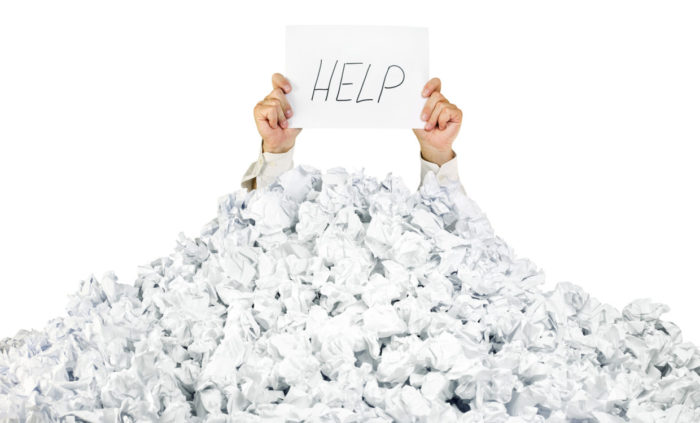 A under a crumbled pile of paper looking for help